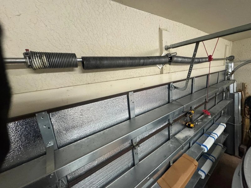Long springs mounted along the horizontal track above a sectional garage door